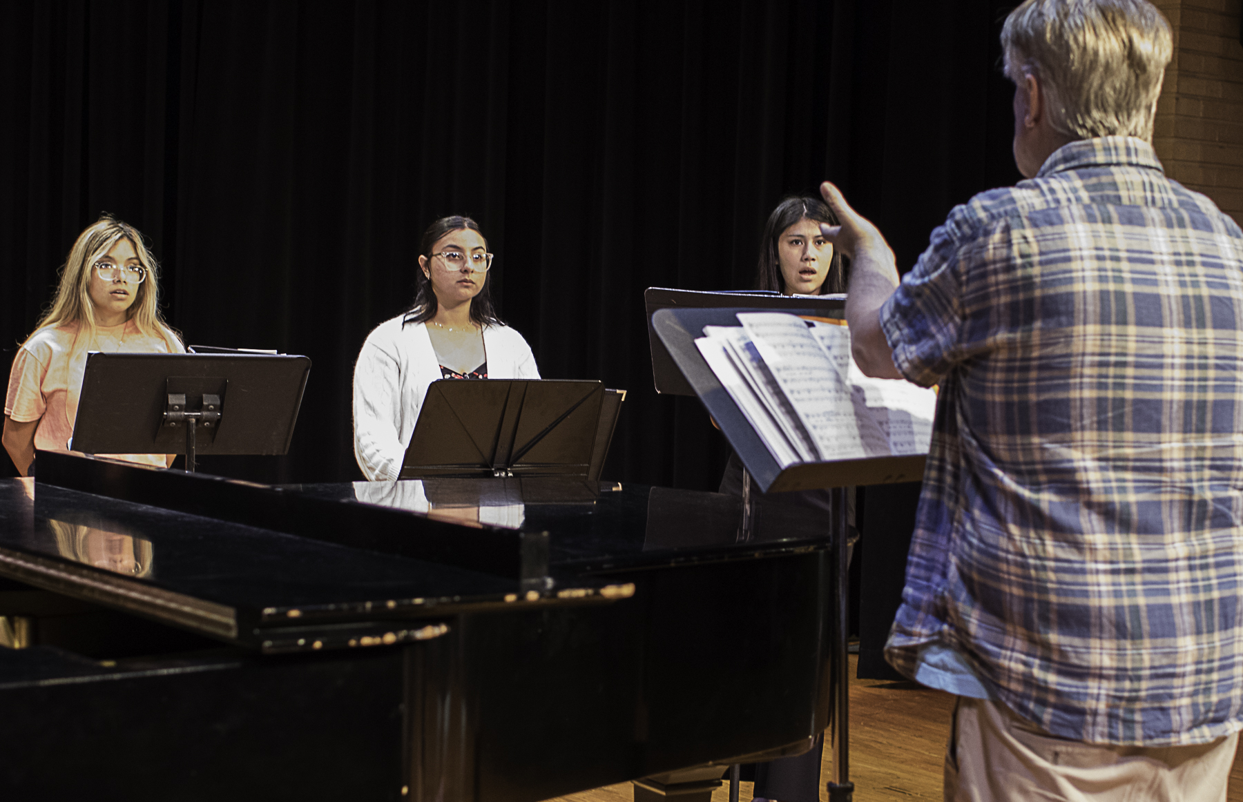 The Wharton County Junior College Choir will present "The Evolution of Music" on Tuesday, Oct. 14, in the Horton Foote Theatre on the Wharton campus. Pictured taking direction from WCJC Choir Director Dr. Karl Paoletti are, from left, Anahiyarith Rodriguez of El Campo, Alexis Alvarez of Bay City and Vanesa Flores of Needville.